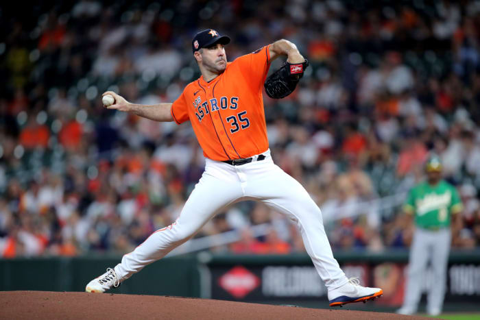 Justin Verlander throws a pitch wearing an orange Astros uniform
